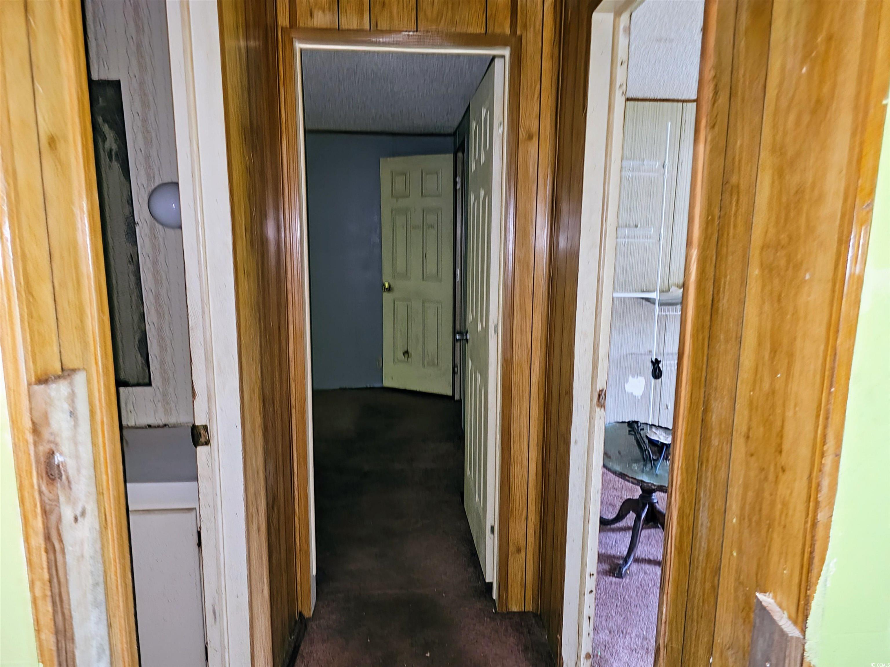 827 1/2 North Firetower Road Florence, SC 29506 - Photo 15 of 29 Hallway featuring wood walls and dark colored carpet
