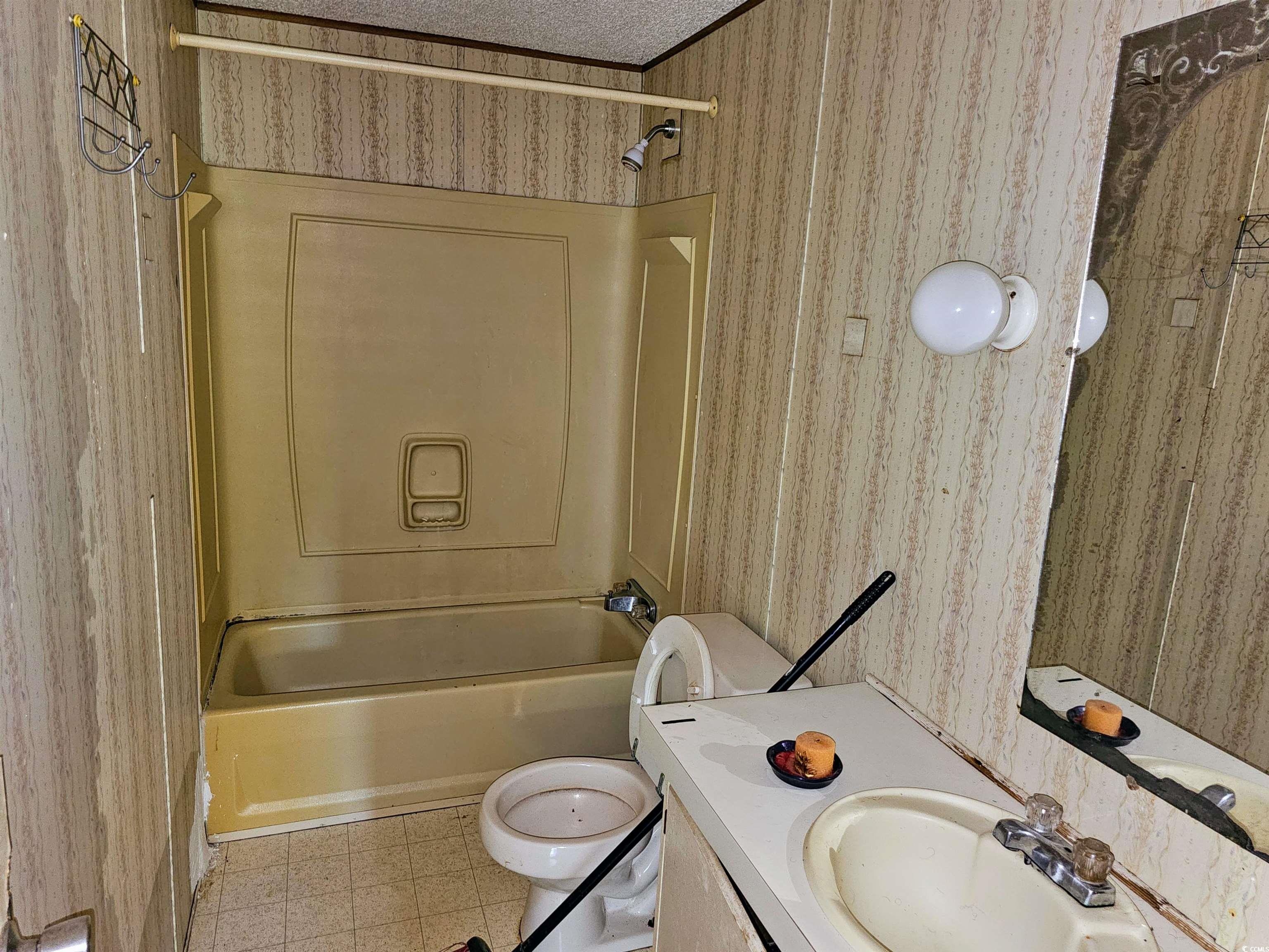 827 1/2 North Firetower Road Florence, SC 29506 - Photo 16 of 29 Bathroom featuring wallpapered walls, shower / tub combination, tile patterned floors, and vanity
