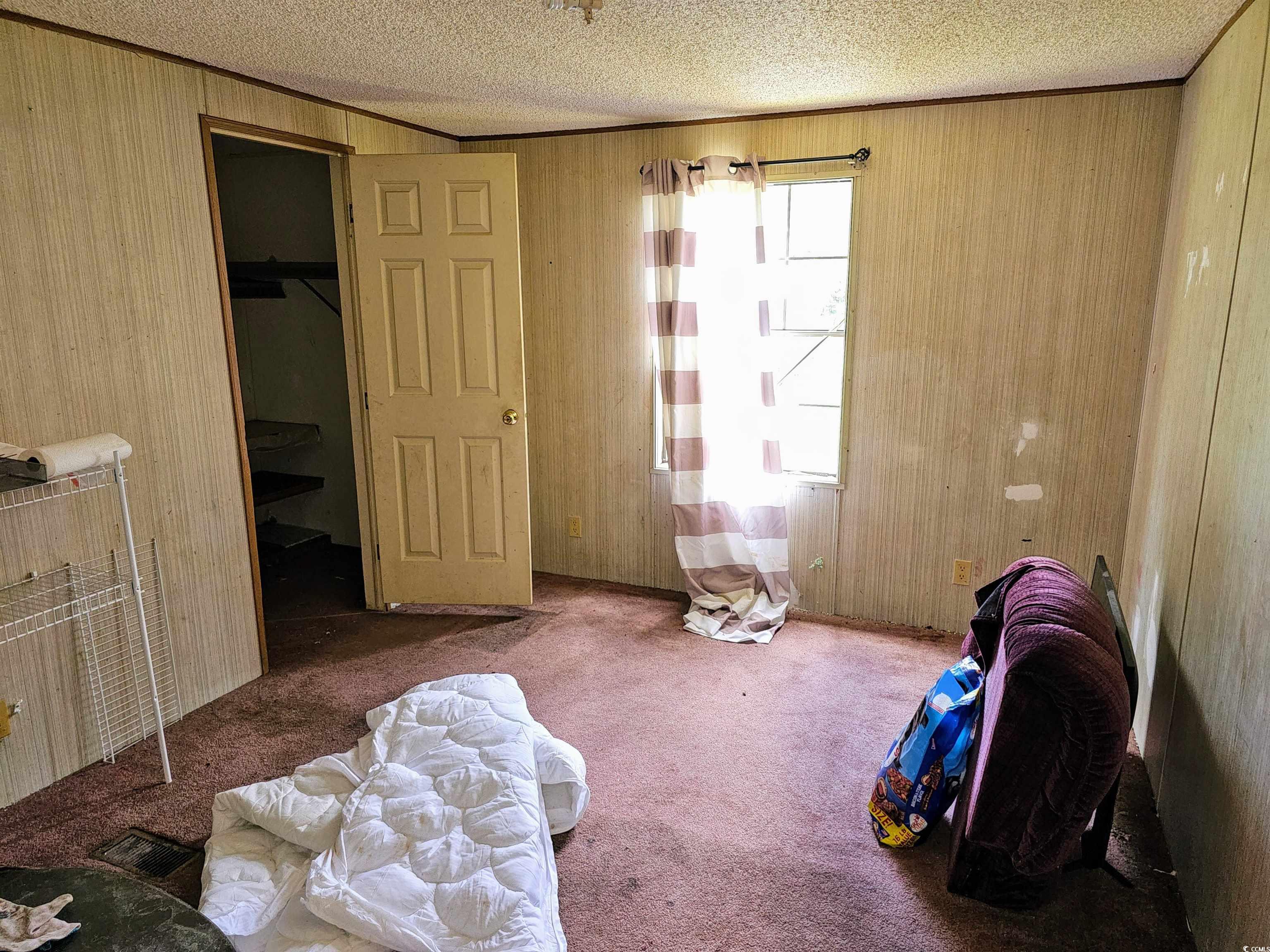 827 1/2 North Firetower Road Florence, SC 29506 - Photo 17 of 29 Bedroom with carpet floors, wood walls, crown molding, and a textured ceiling