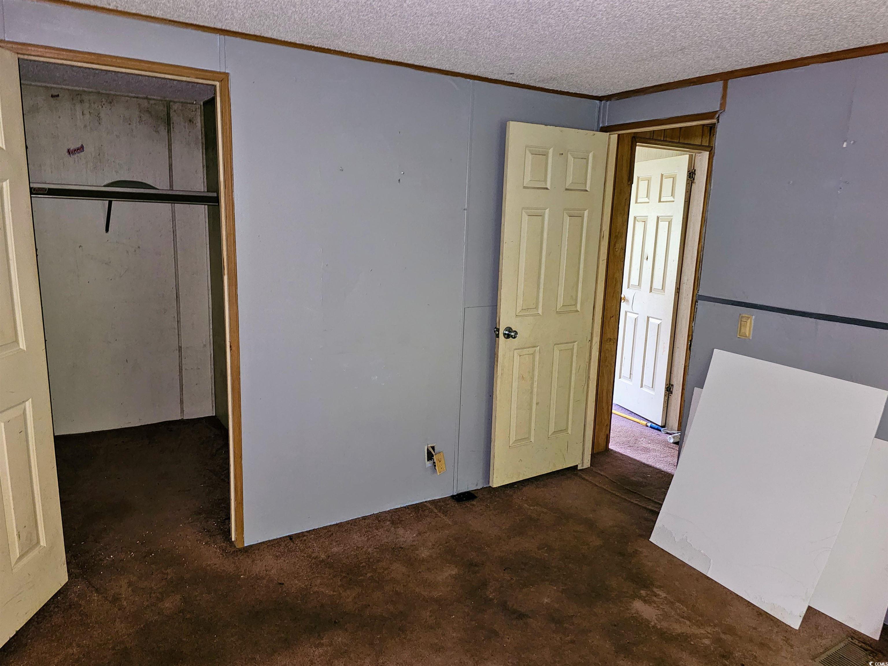 827 1/2 North Firetower Road Florence, SC 29506 - Photo 20 of 29 Unfurnished bedroom featuring a closet, a textured ceiling, and crown molding