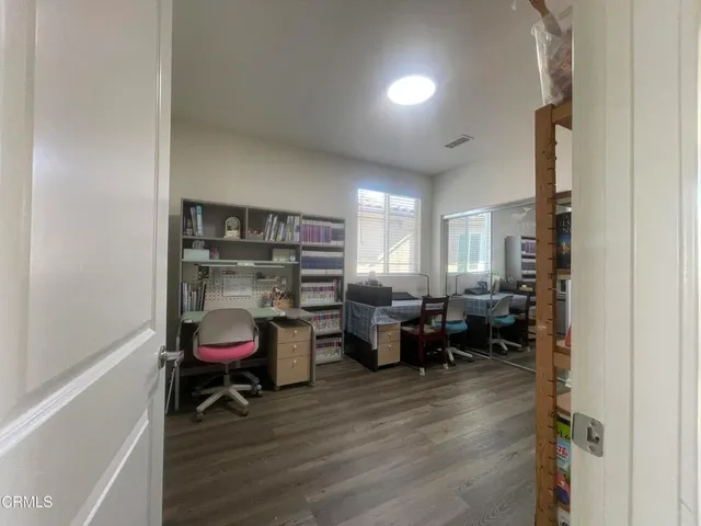 a view of a room with a table chairs and windows