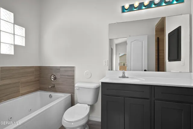 a bathroom with a sink a toilet a mirror and bathtub