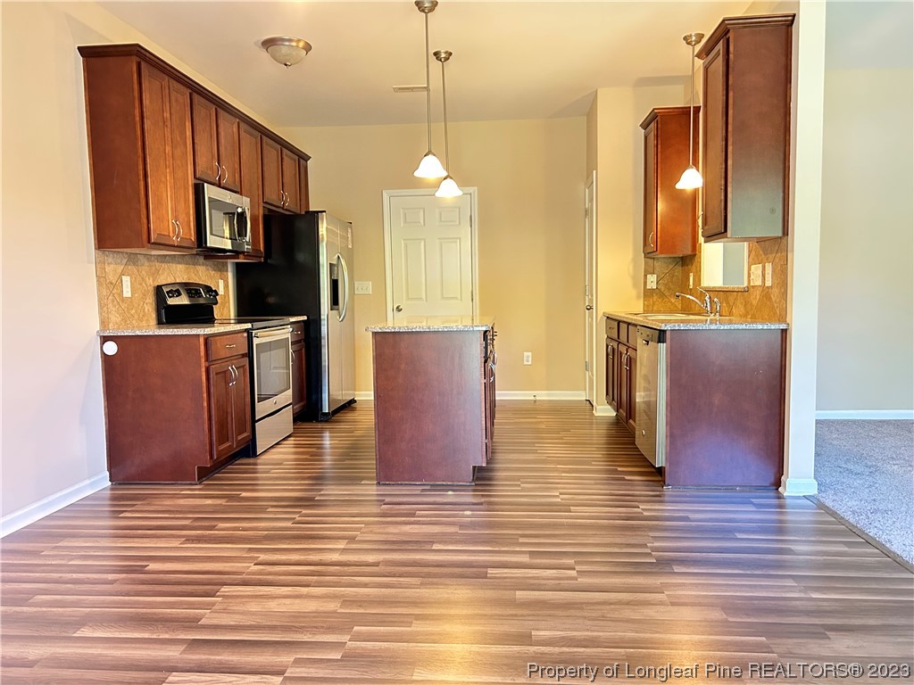 145 Taplow Trail Cameron, NC 28326 - Photo 3 of 15 a view of a kitchen with kitchen island wooden floors stainless steel appliances