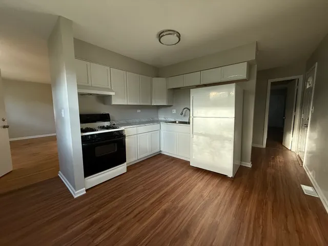a kitchen with wooden floors and appliances
