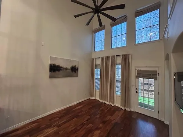 a view of a livingroom with wooden floor and a ceiling fan