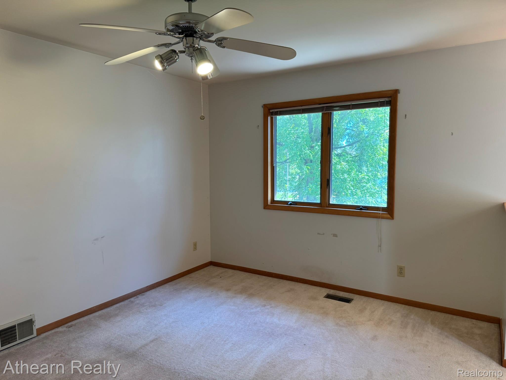 11449 Torrey Road Fenton, MI 48430 - Photo 24 of 30 Room featuring light-toned carpeting, a window with wood-finish trim, and a ceiling fan with integrated lighting