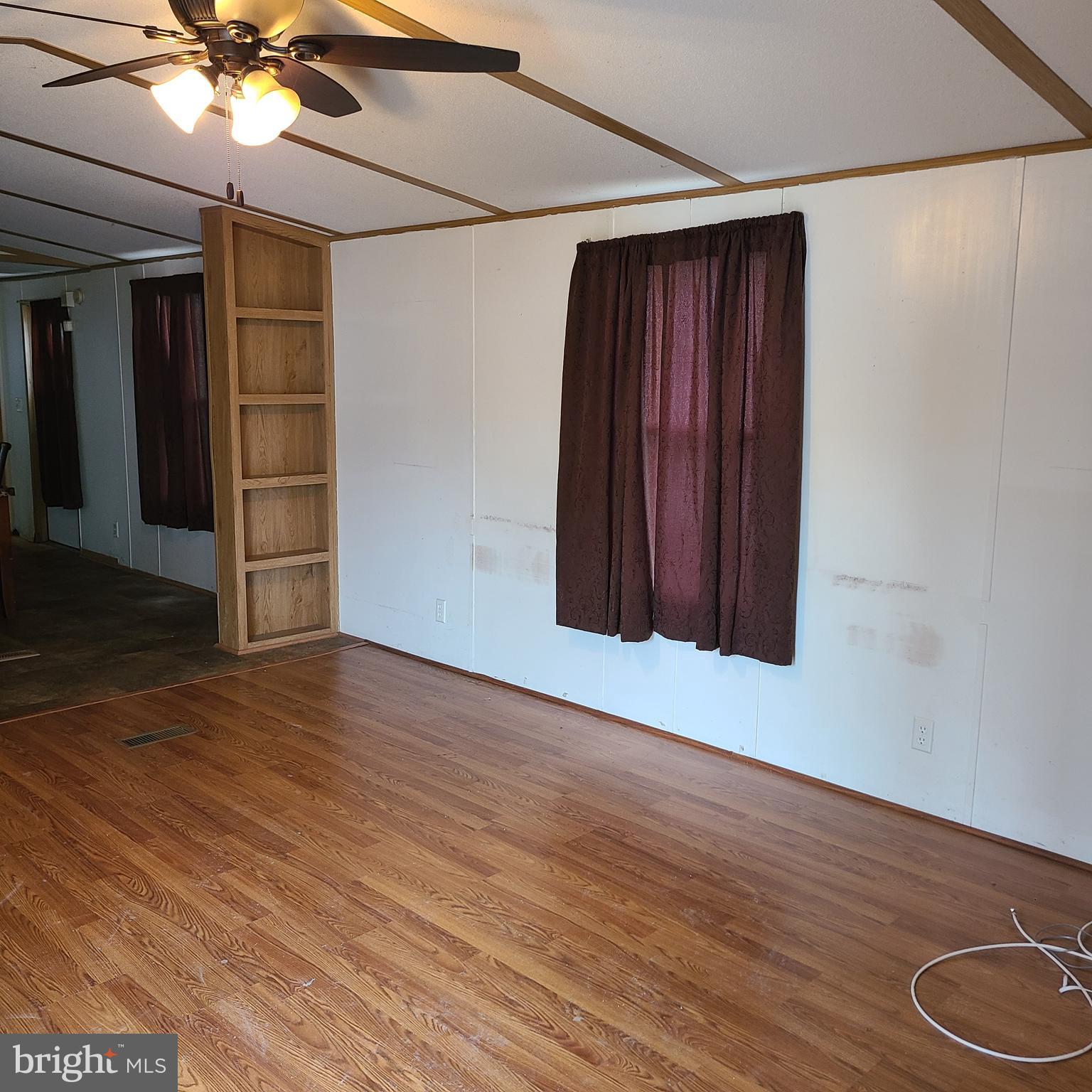 1679 South State Street, Unit A50 Dover, DE 19901 - Photo 4 of 6 a view of an empty room with wooden floor and a ceiling fan