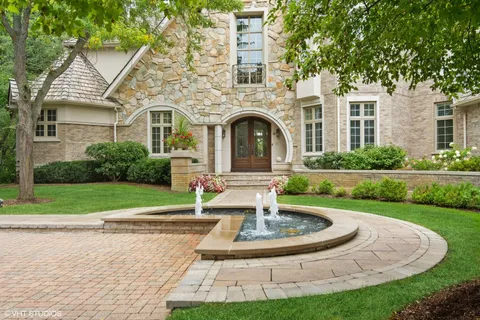 a view of a white house with a yard and large trees