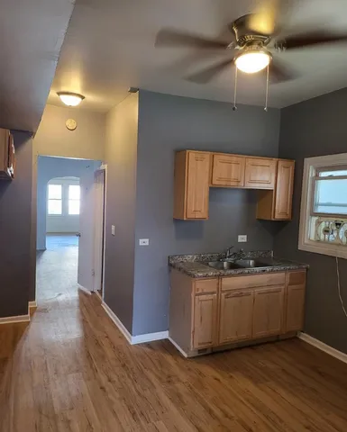 a kitchen with stainless steel appliances a sink cabinets and wooden floor