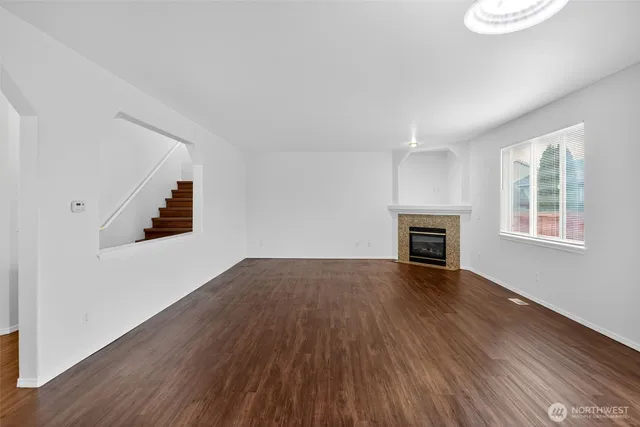 an empty room with wooden floor and fireplace