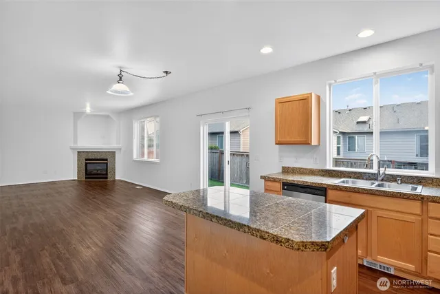 a kitchen with granite countertop a sink and a stove top oven