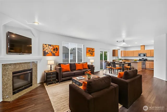 a living room with furniture a flat screen tv and a fireplace