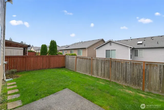 a view of backyard with barbeque and wooden fence