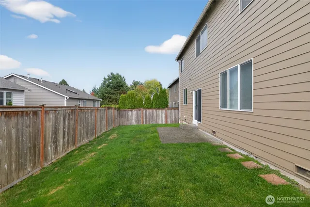 a view of a backyard with potted plants and wooden fence