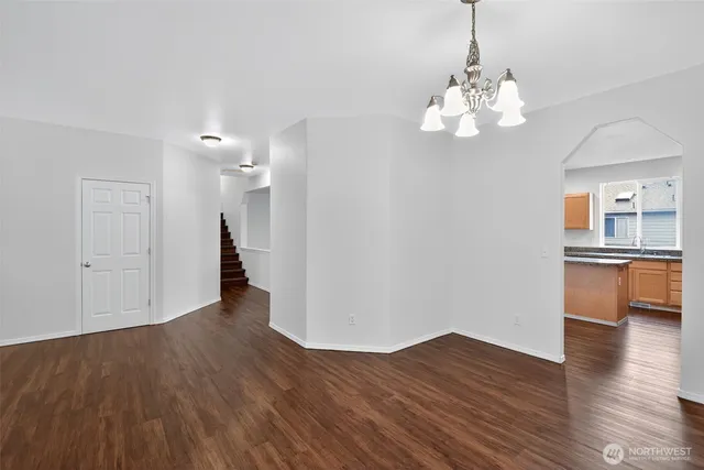 a view of a room with wooden floor and kitchen