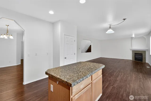 a kitchen with kitchen island a sink appliances and wooden floor