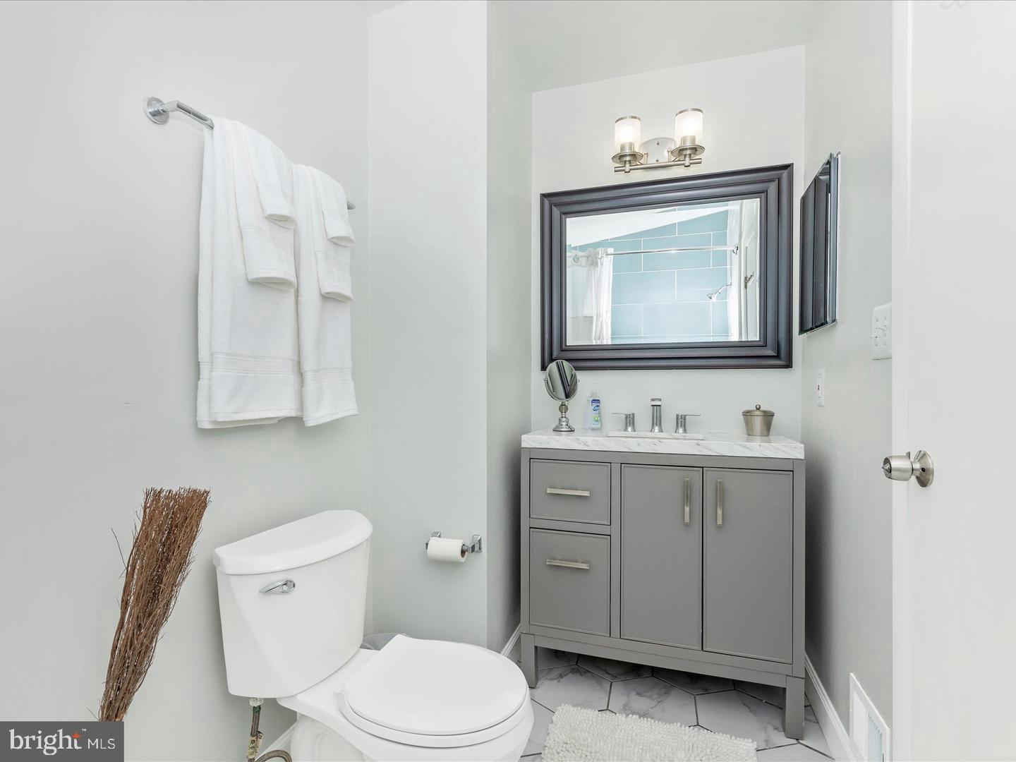 11349 Appledowre Way, Unit 313 Germantown, MD 20876 - Photo 14 of 27 a bathroom with a toilet sink vanity and mirror