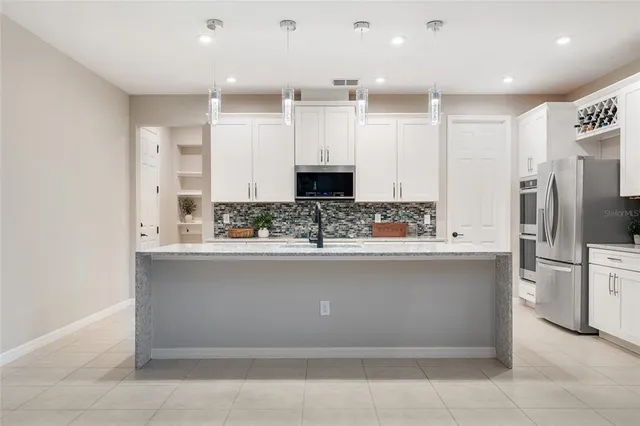 a spacious bedroom with a bed and a chandelier