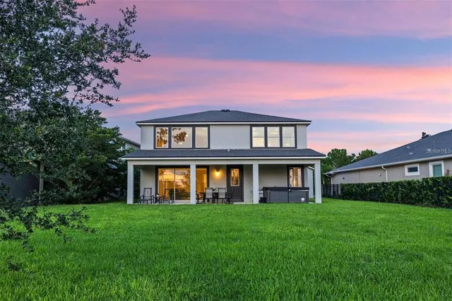 an aerial view of a house with a garden and lake view