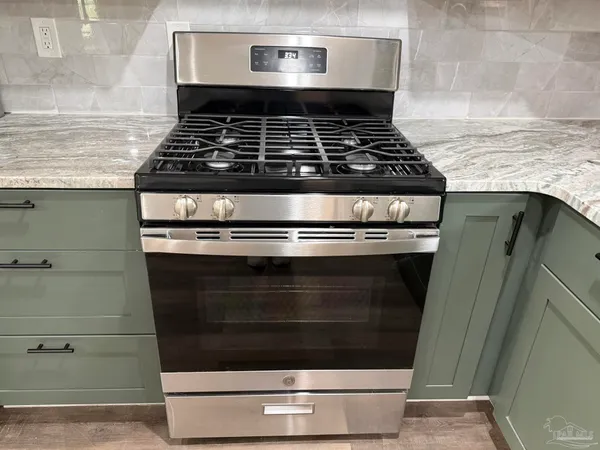 a stove top oven sitting inside of a kitchen