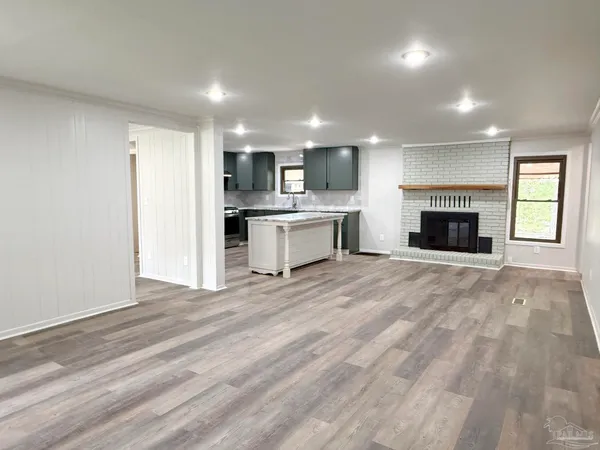 an open kitchen with fireplace dining space and windows