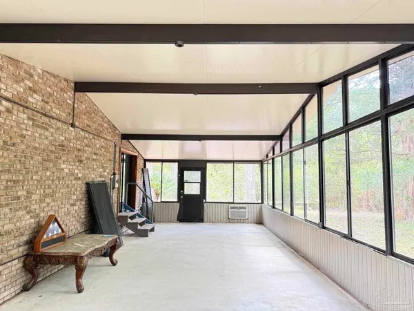 a view of a room with furniture and large windows