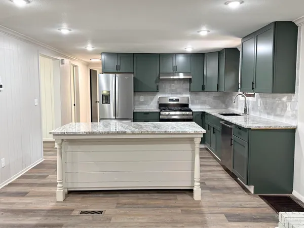 a kitchen with kitchen island stainless steel appliances a sink and stove