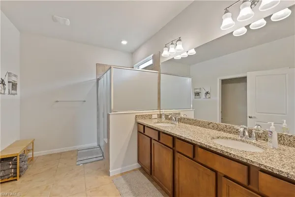 a bathroom with a granite countertop sink a mirror and a shower