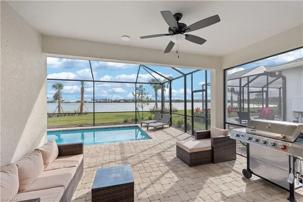 a living room with furniture and a large window with pool view