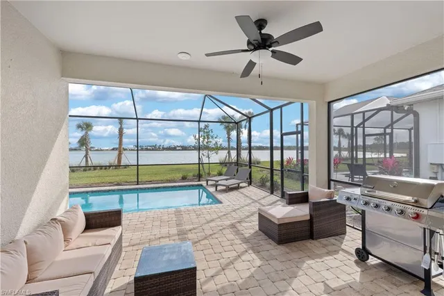 a living room with furniture and a large window with pool view