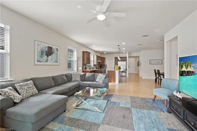 a living room with furniture kitchen view and a wooden floor