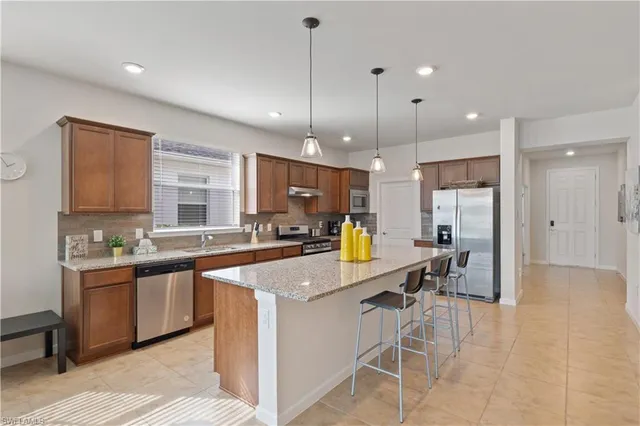 a kitchen with stainless steel appliances kitchen island granite countertop a sink and cabinets