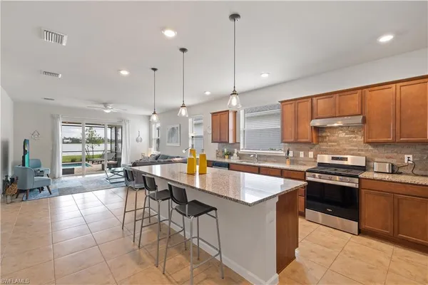a large kitchen with lots of counter space a sink appliances and a counter top space