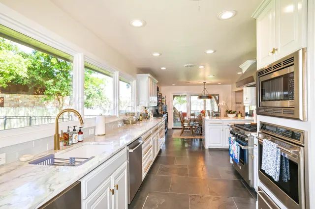 a kitchen with a sink appliances cabinets and a counter top space
