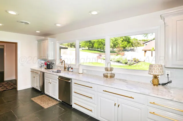 a large white kitchen with a large window