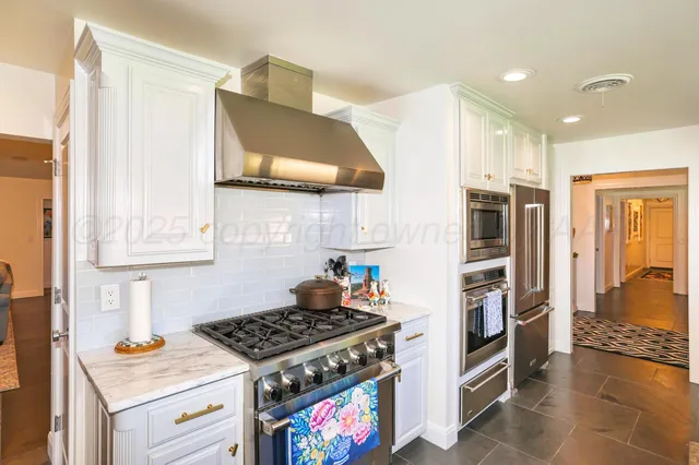 a dining room with stainless steel appliances kitchen island granite countertop a dining table and chairs with wooden floor