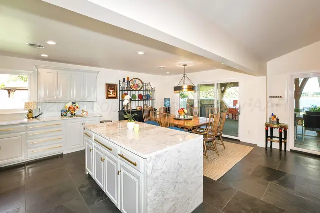 a dining room with furniture a chandelier and wooden floor