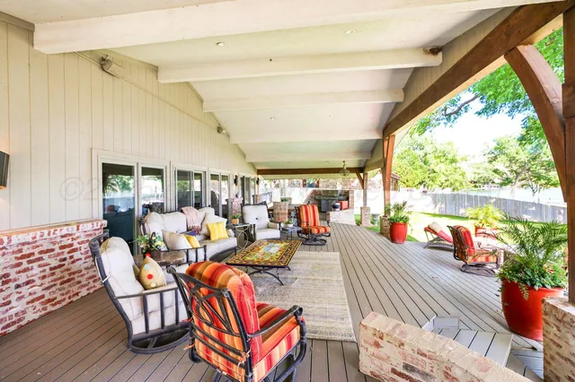 a view of swimming pool with lounge chair and dinning table under large trees