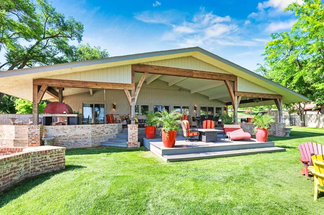 a view of a swimming pool with lawn chairs and floor to ceiling window