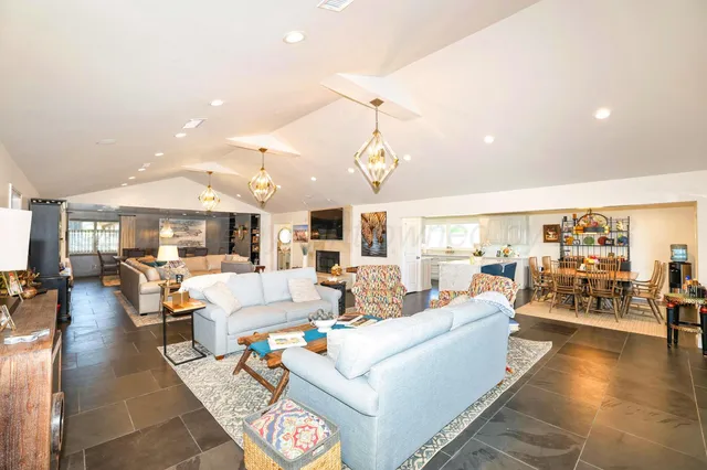 a living room with fireplace furniture and a large window