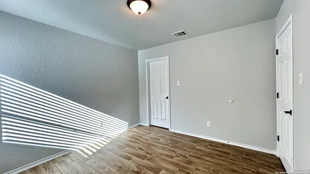a view of a room with wooden floor