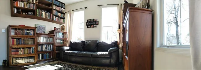 a living room with furniture cabinets and a window