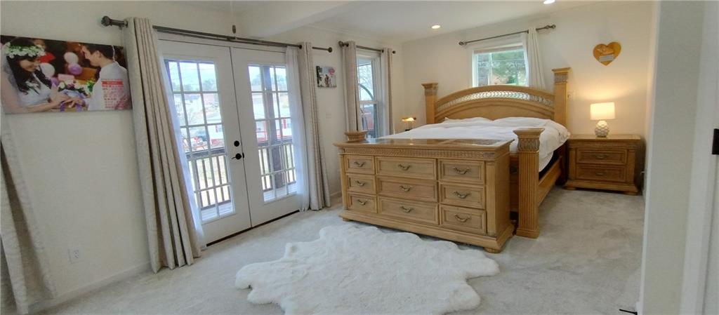 125 Strippling Street Ball Ground, GA 30107 - Photo 8 of 35 a spacious bedroom with a balcony a bed and a dresser