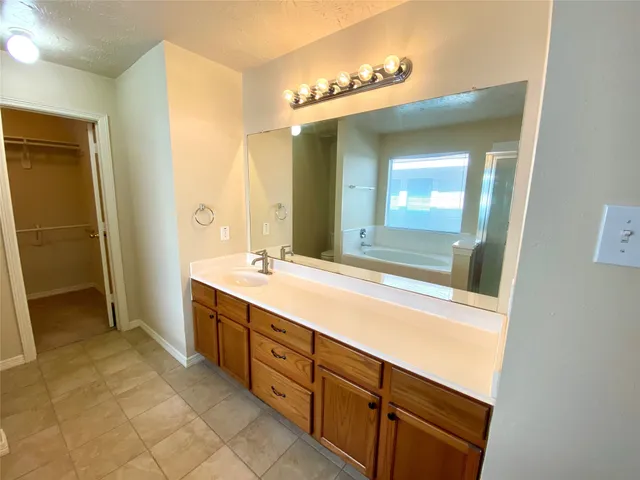 a spacious bathroom with a double vanity sink a mirror and a