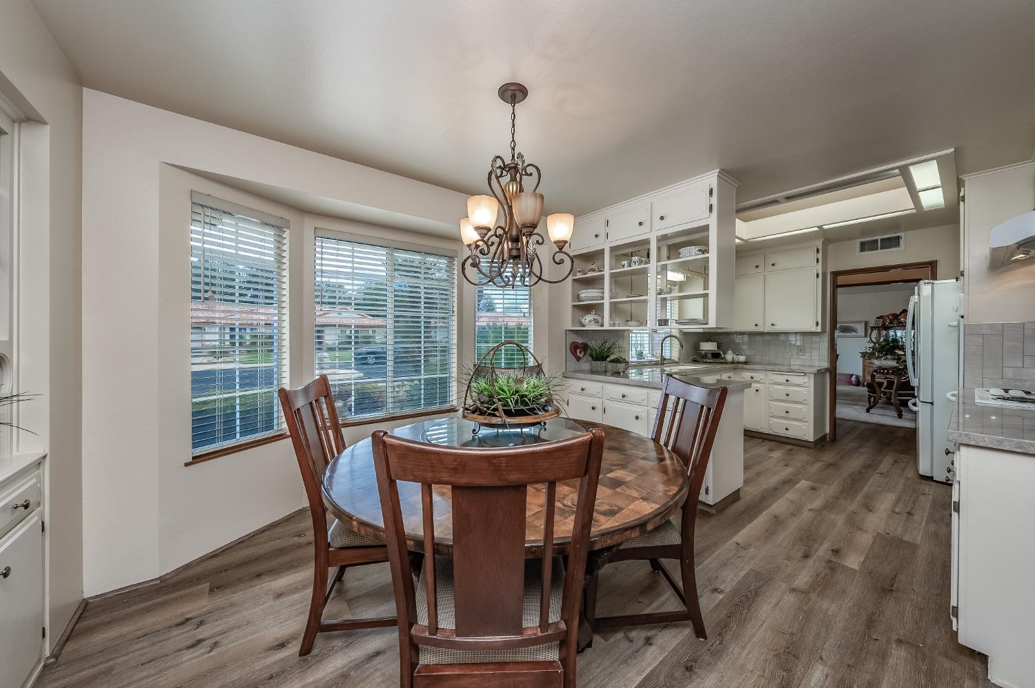 2370 Jonathan Way Madera, CA 93637 - Photo 11 of 41 a dining room with furniture a chandelier and wooden floor