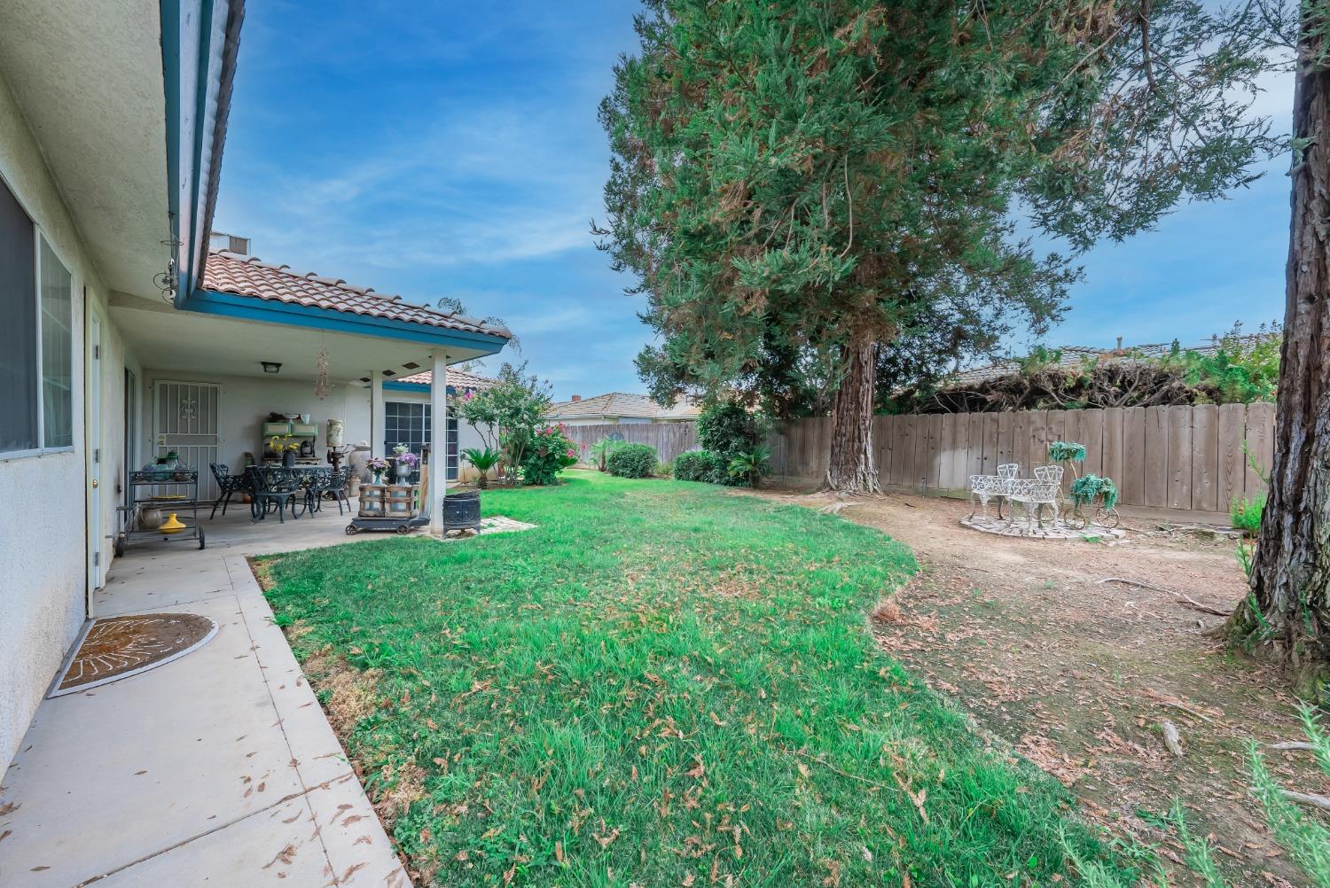 2370 Jonathan Way Madera, CA 93637 - Photo 25 of 41 a view of a patio with table and chairs potted plants and a large tree