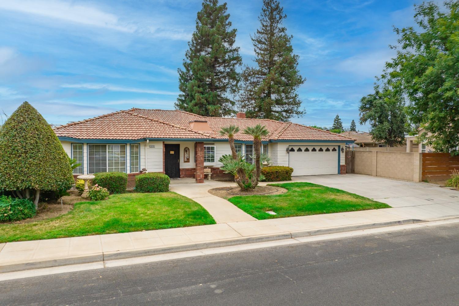 2370 Jonathan Way Madera, CA 93637 - Photo 30 of 41 a view of a white house with a yard plants and large tree