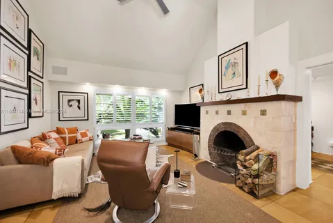 a living room with furniture large window and fireplace