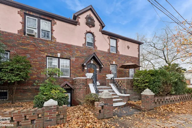 a front view of a house with plants