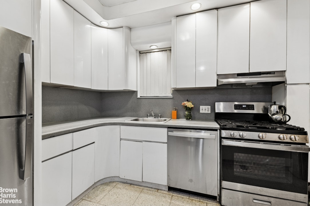 1702 East 28th Street Brooklyn, NY 11229 - Photo 9 of 17 a kitchen with white cabinets and appliances